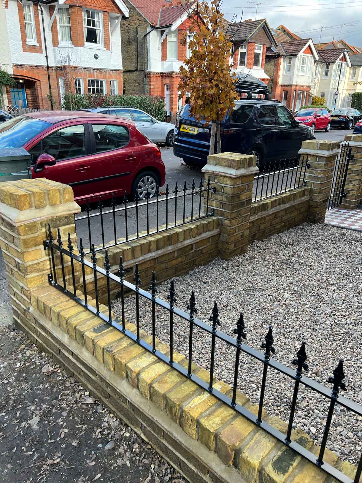 A yellow brick wall and a red and white victorian path in checkerboard style.