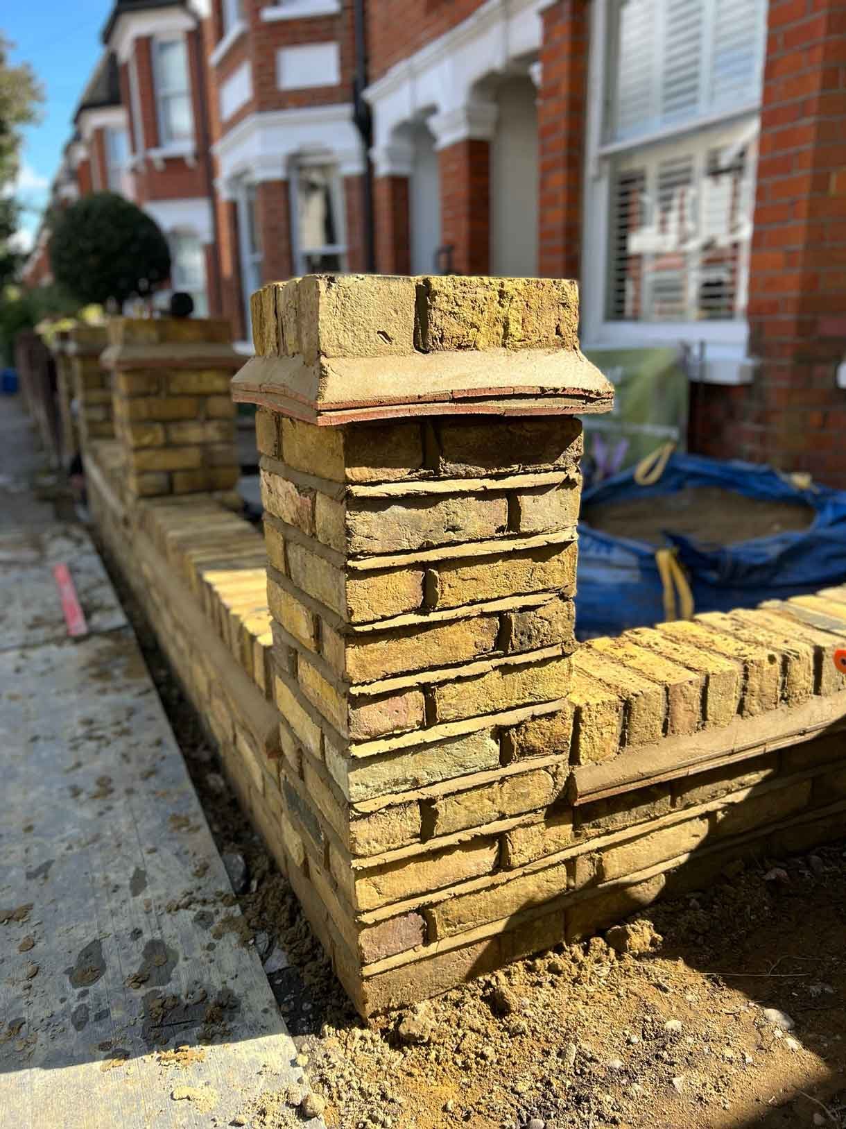 A yellow brick pier column as part of the wall rebuild