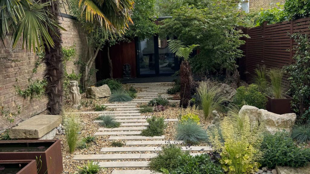 Gravel garden with stepping stones, ornamental grasses, palm and drought-tolerant planting