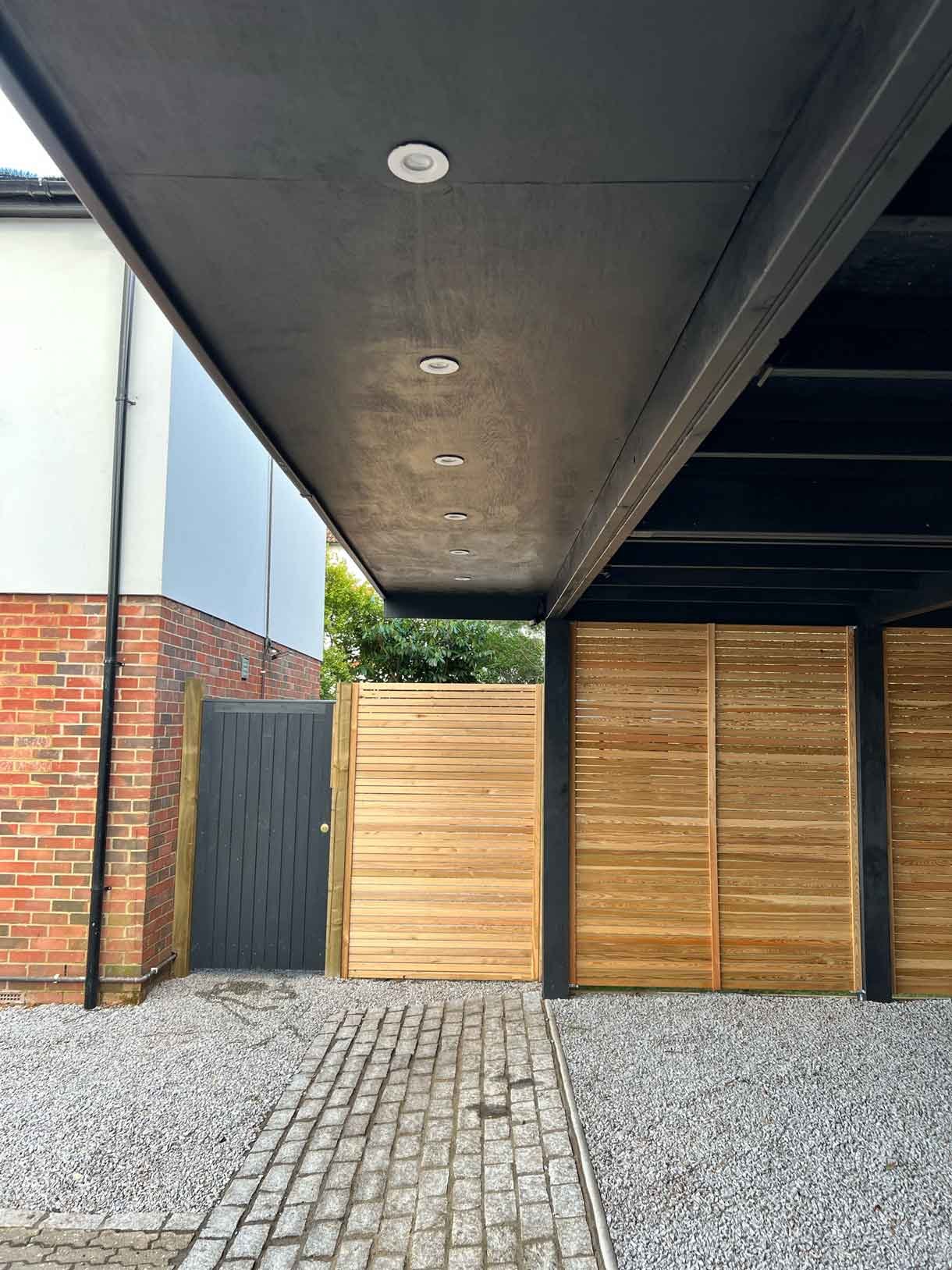 A carport made from Siberian larch panels and a gravel drive to house the clients vehicles.