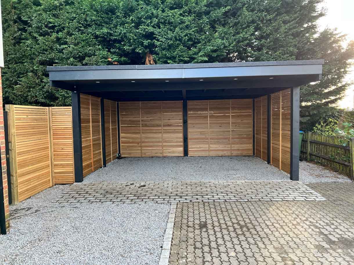 A carport made from Siberian larch panels and a gravel drive to house the clients vehicles.