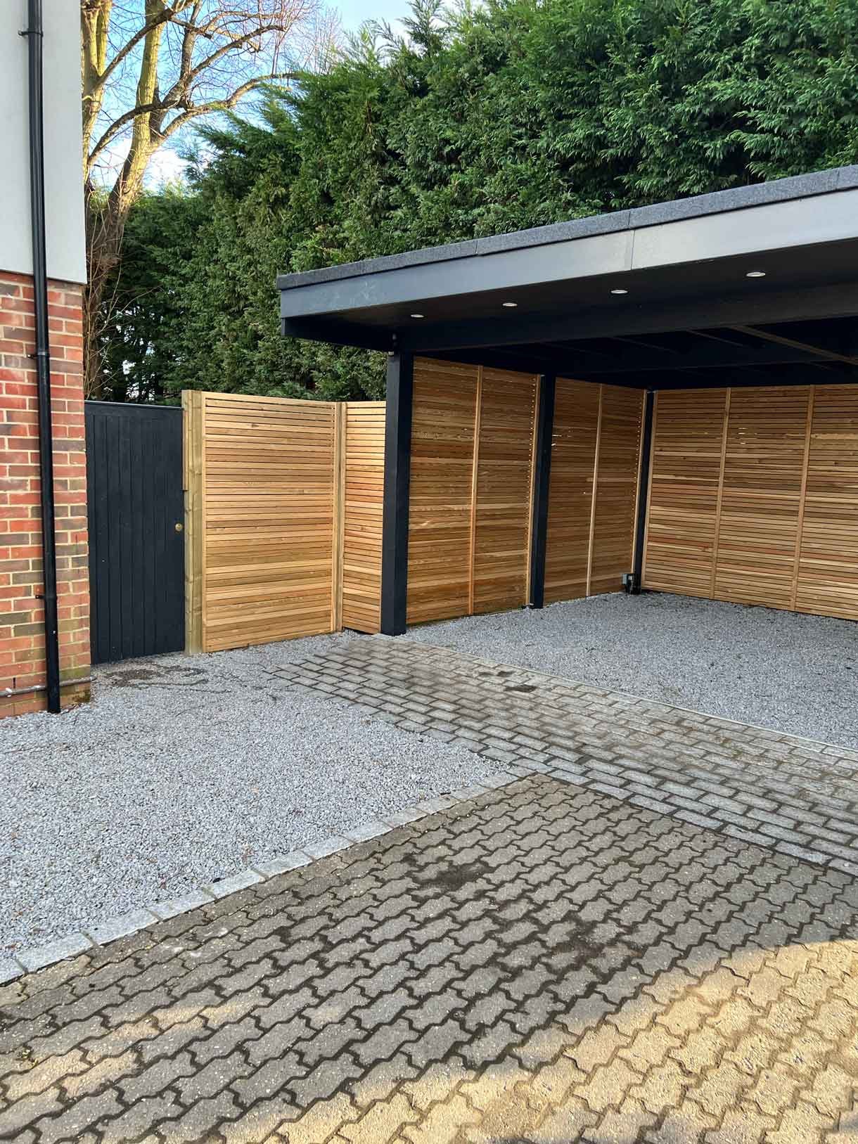 A carport made from Siberian larch panels and a gravel drive to house the clients vehicles.
