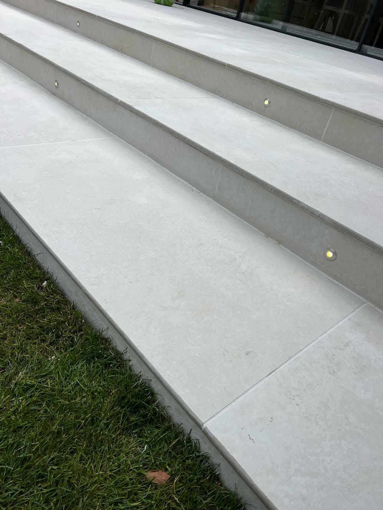 Recessed light into riser of the patio step in white porcelain