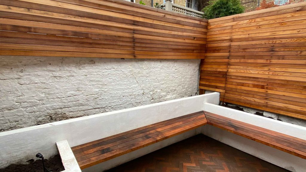 Hardwood cedar decking and built-in bench in contemporary Chelsea courtyard garden