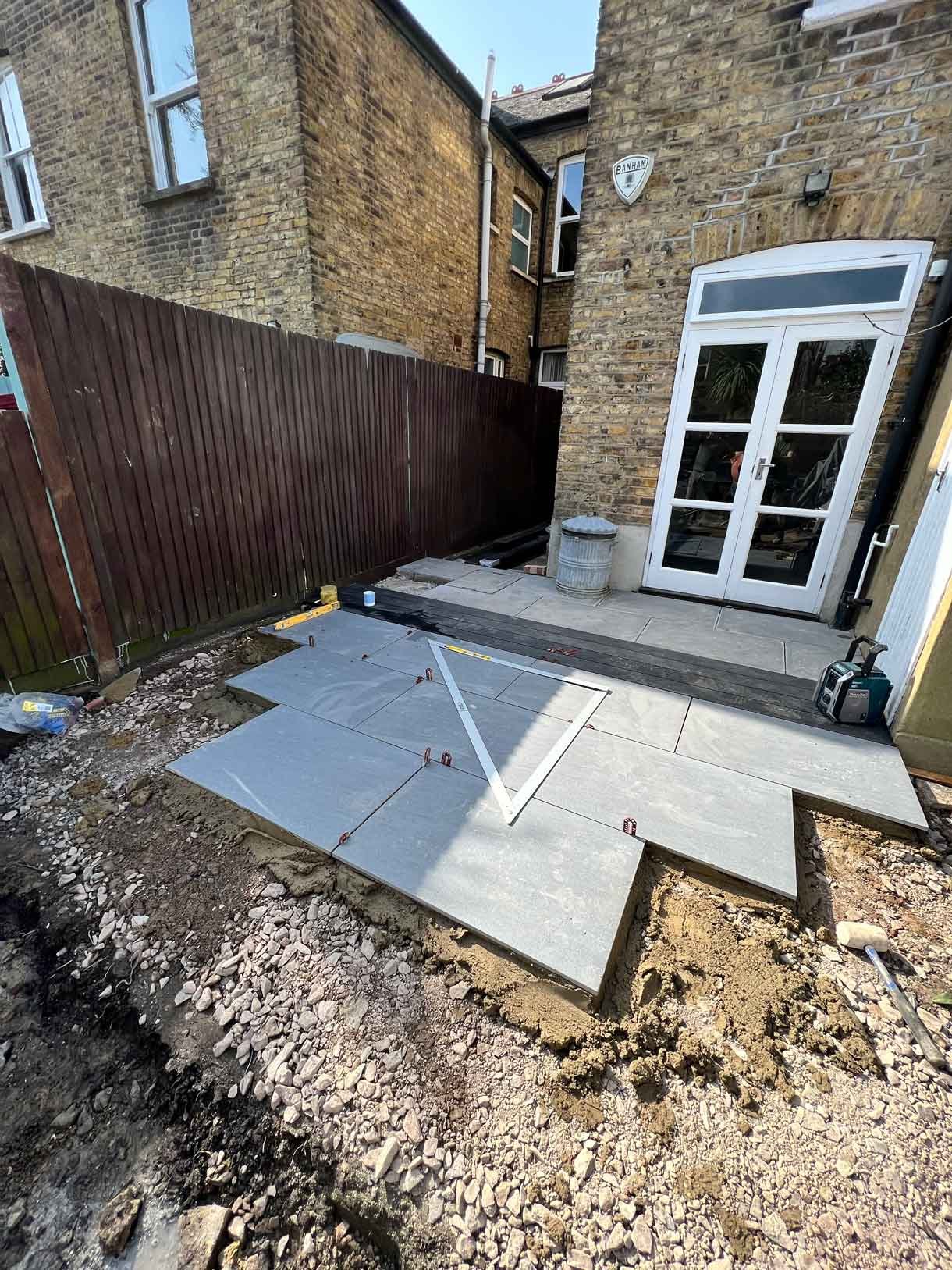Garden redesign, using porcelain and composite decking and white rendered planters in Ealing, West London.