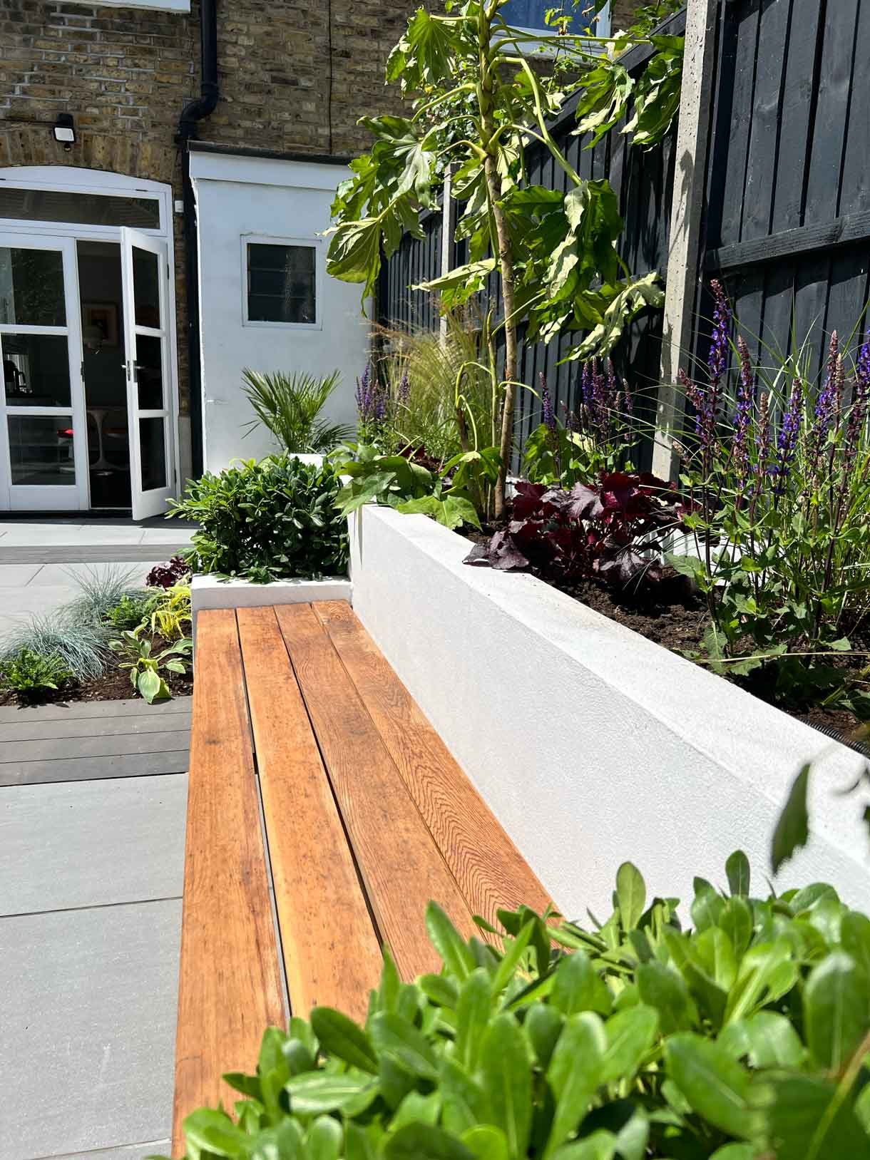 Garden redesign, using porcelain and composite decking and white rendered planters in Ealing, West London.