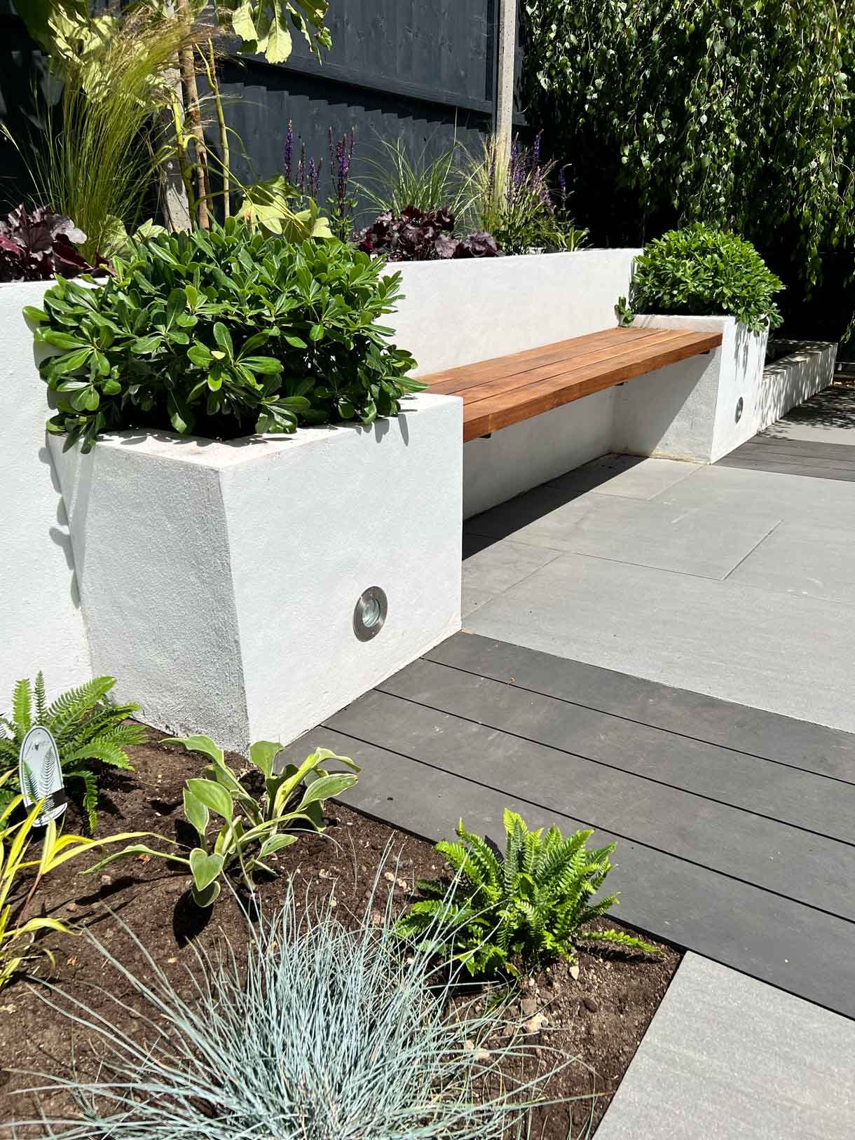 Garden redesign, using porcelain and composite decking and white rendered planters in Ealing, West London.