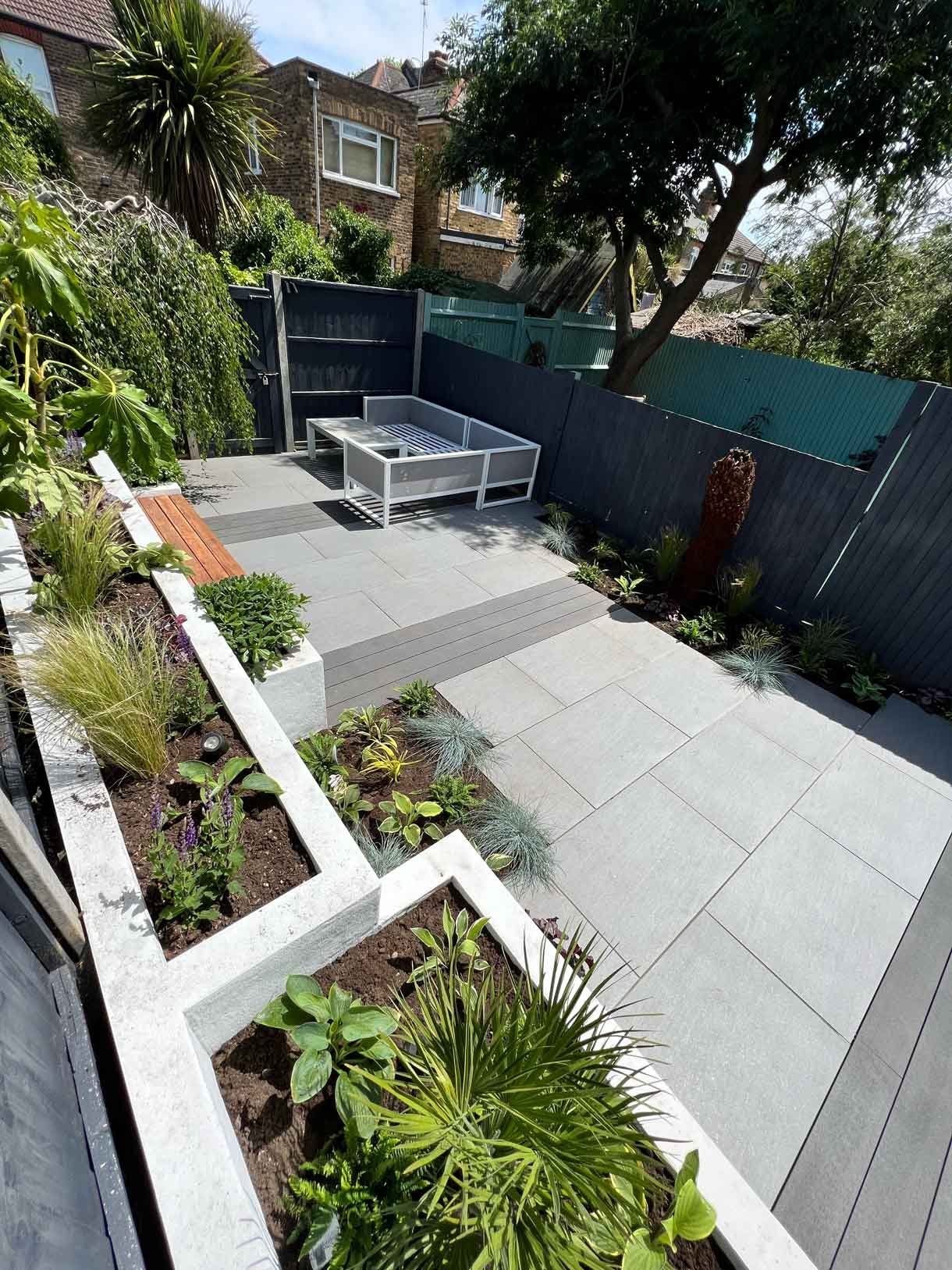 Garden redesign, using porcelain and composite decking and white rendered planters in Ealing, West London.