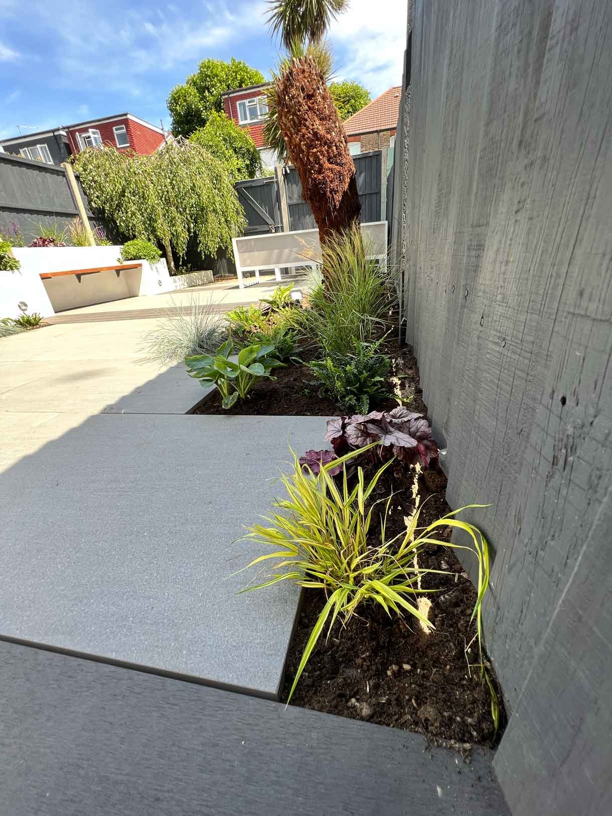 Garden redesign, using porcelain and composite decking and white rendered planters in Ealing, West London.