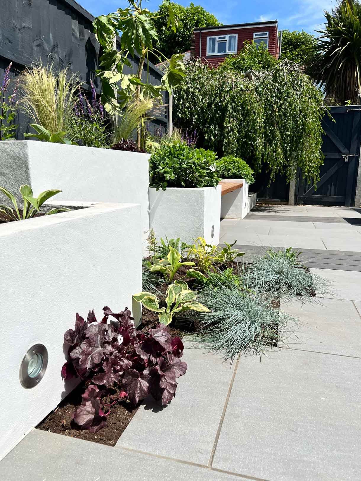 Garden redesign, using porcelain and composite decking and white rendered planters in Ealing, West London.