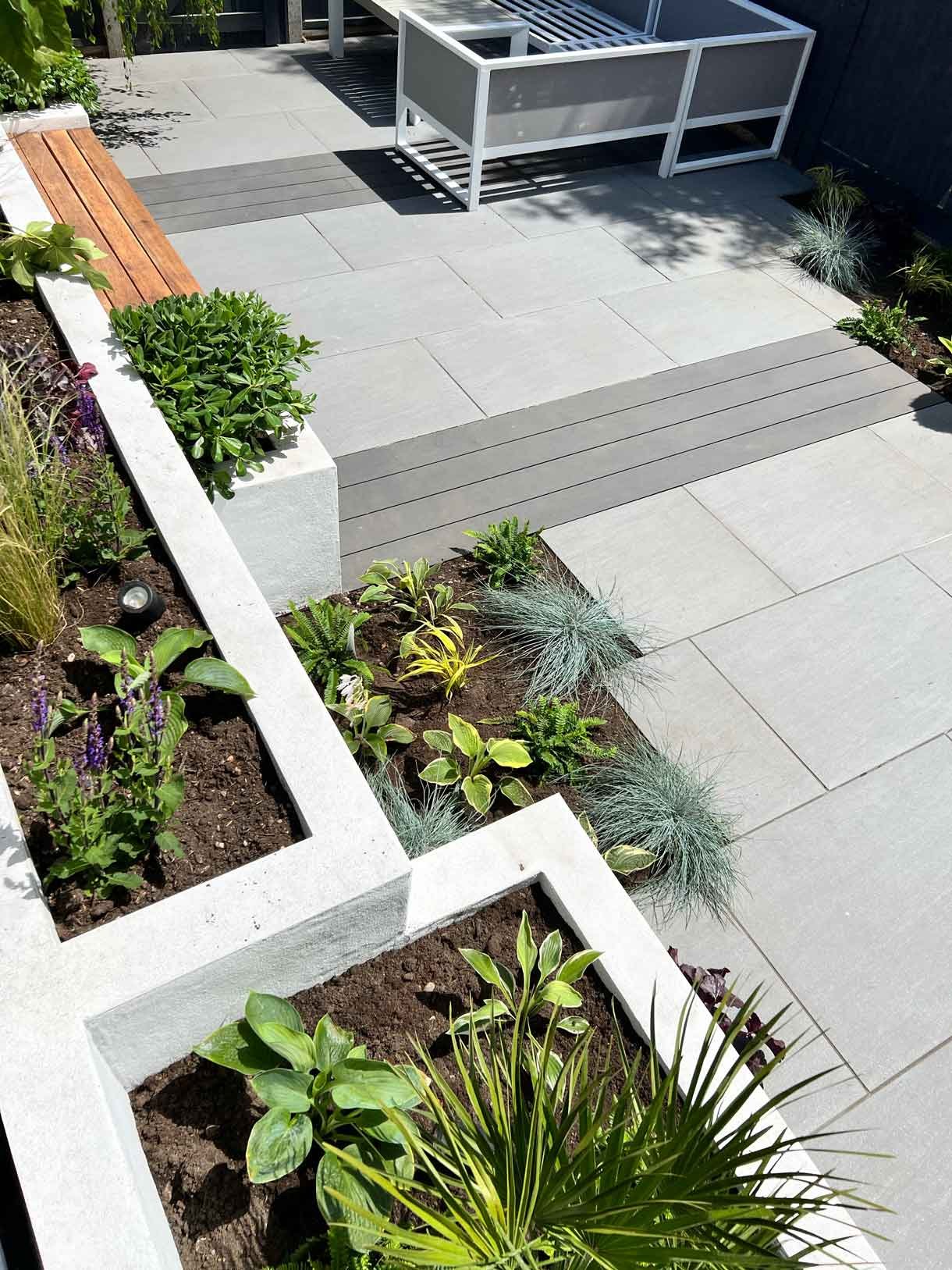 Garden redesign, using porcelain and composite decking and white rendered planters in Ealing, West London.
