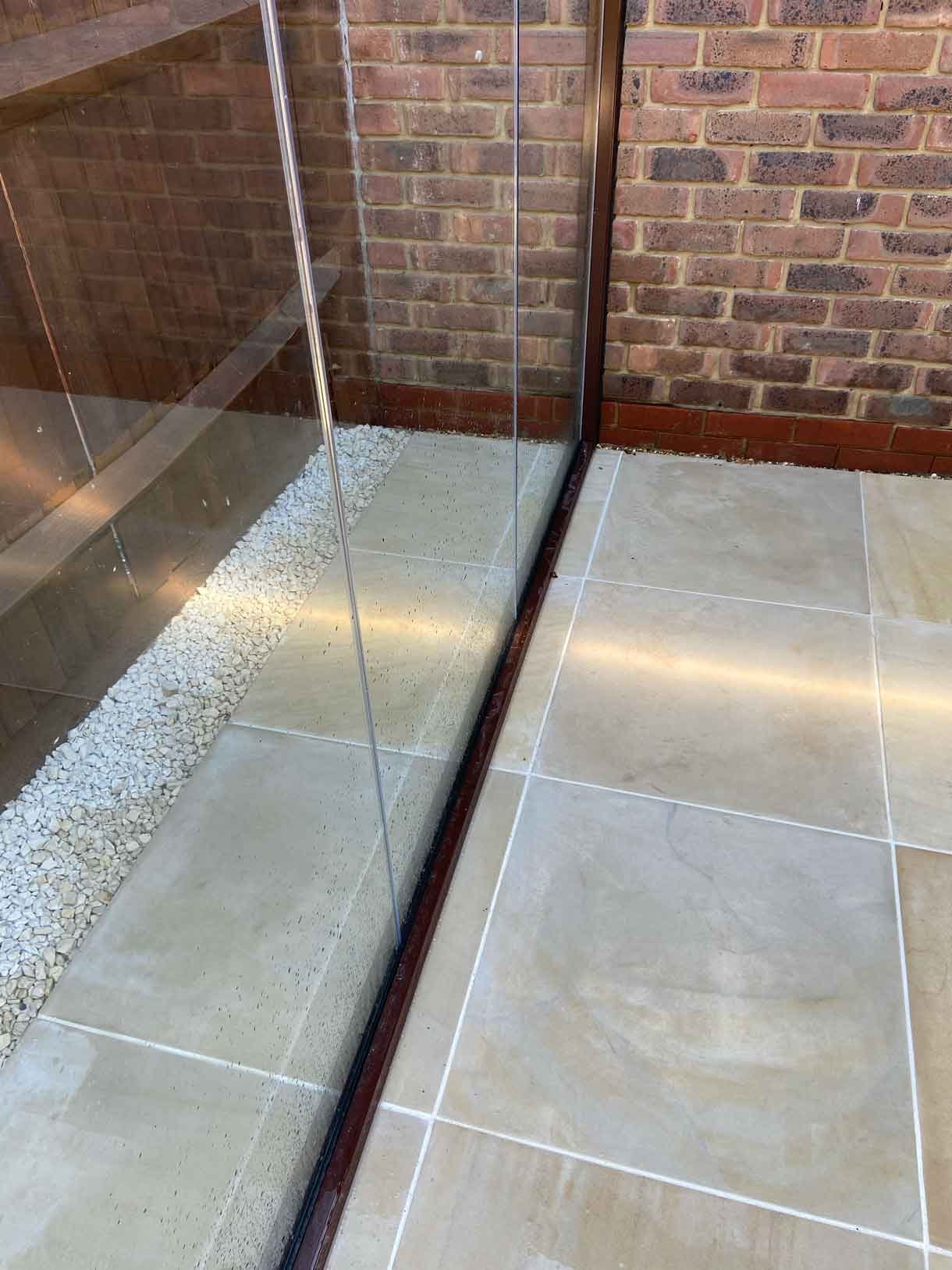 A small courtyard garden in Hammersmith. With sandstone paving and a glass sided pergola.
