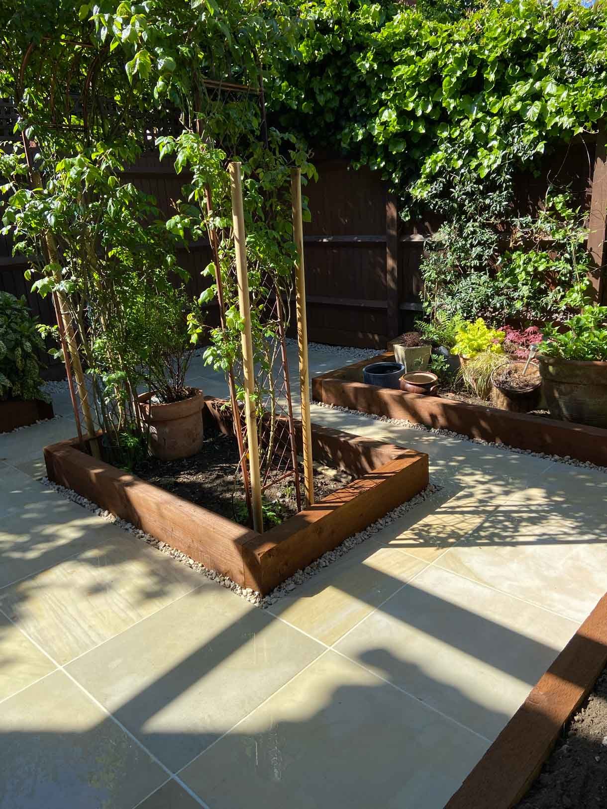 A small courtyard garden in Hammersmith. With sandstone paving and a glass sided pergola.
