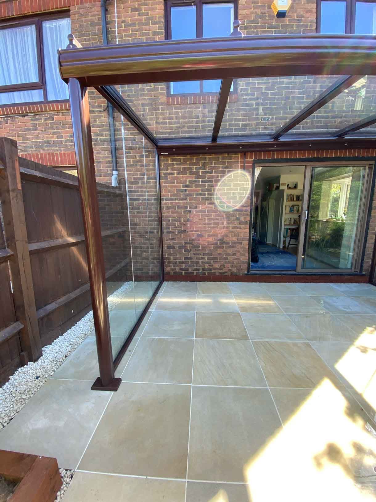 A small courtyard garden in Hammersmith. With sandstone paving and a glass sided pergola.