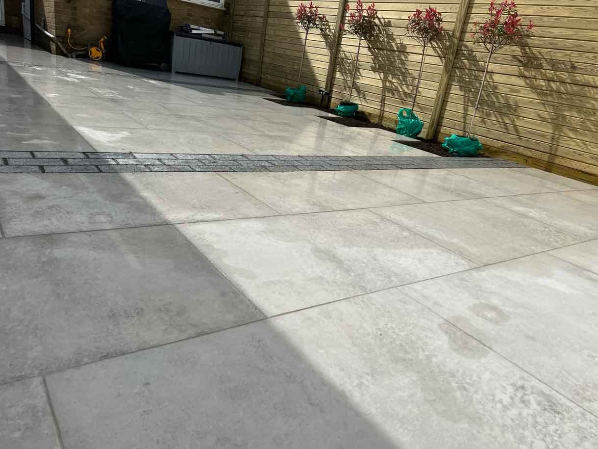 A garden completely paved in porcelain tiles and planted in cut outs of the tiles and raised planters.