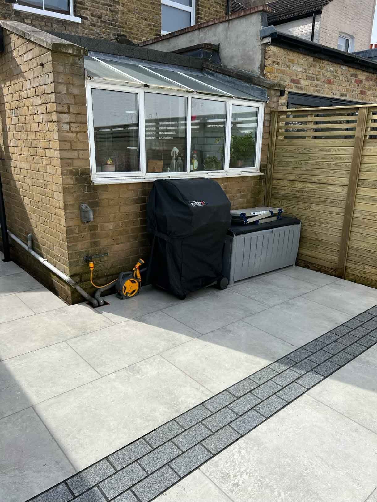 A garden completely paved in porcelain tiles and planted in cut outs of the tiles and raised planters.