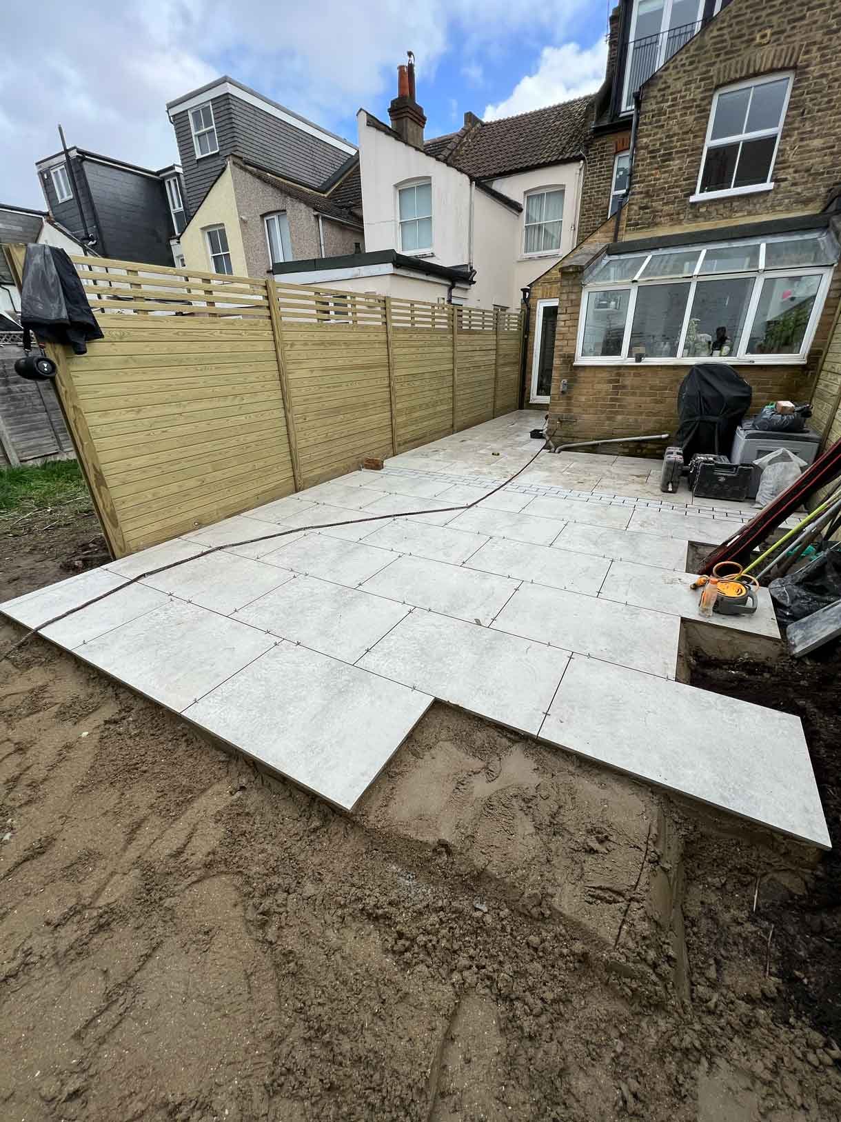 A garden completely paved in porcelain tiles and planted in cut outs of the tiles and raised planters.