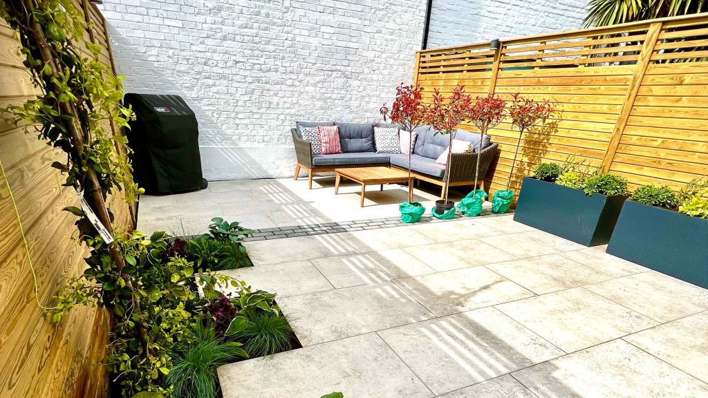 Contemporary minimal garden with large format porcelain paving, modern planters and seating area