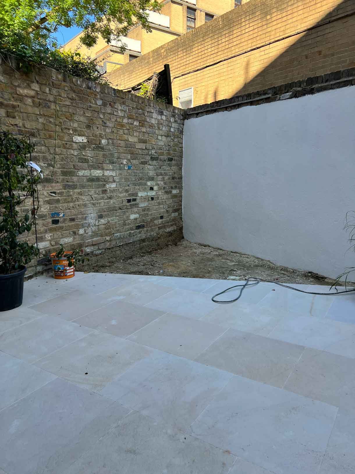 The small garden in need of some plants currently with bins and rubbish from the build in the garden and space.