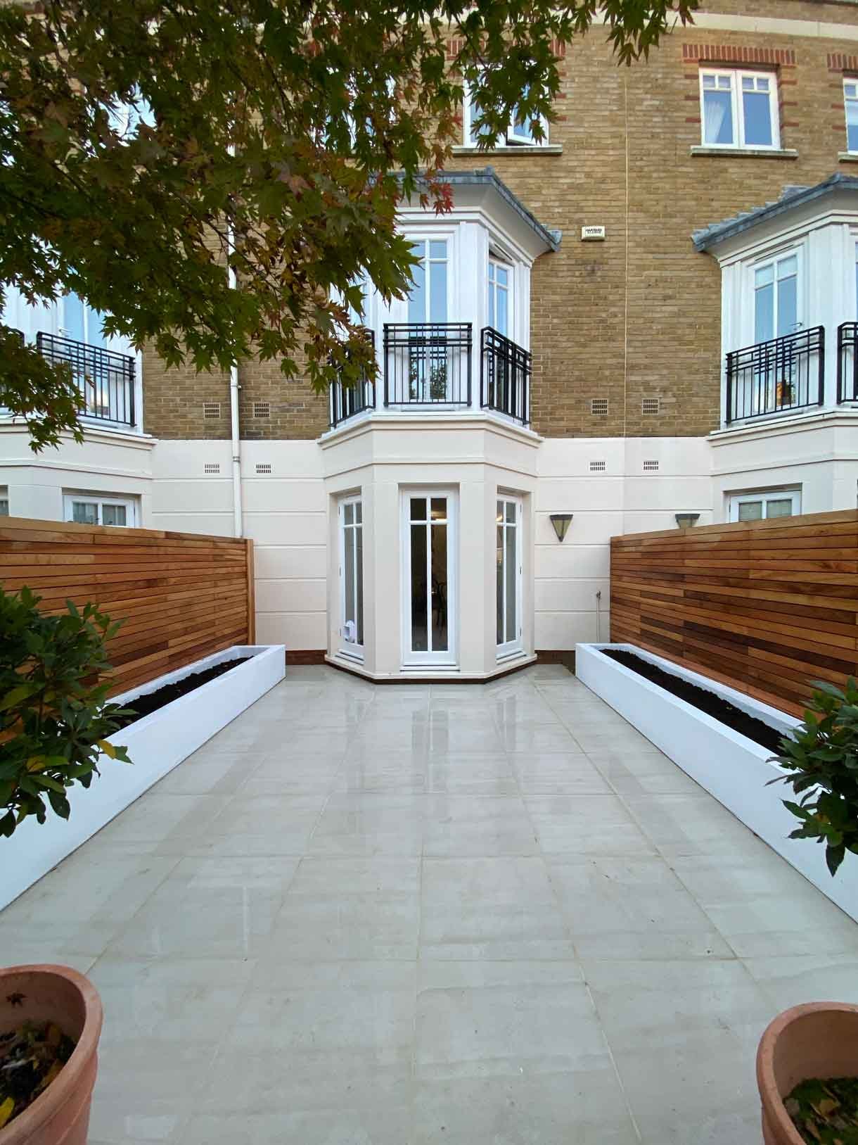 Courtyard garden in Richmond with white rendered planters and cedar fencing.