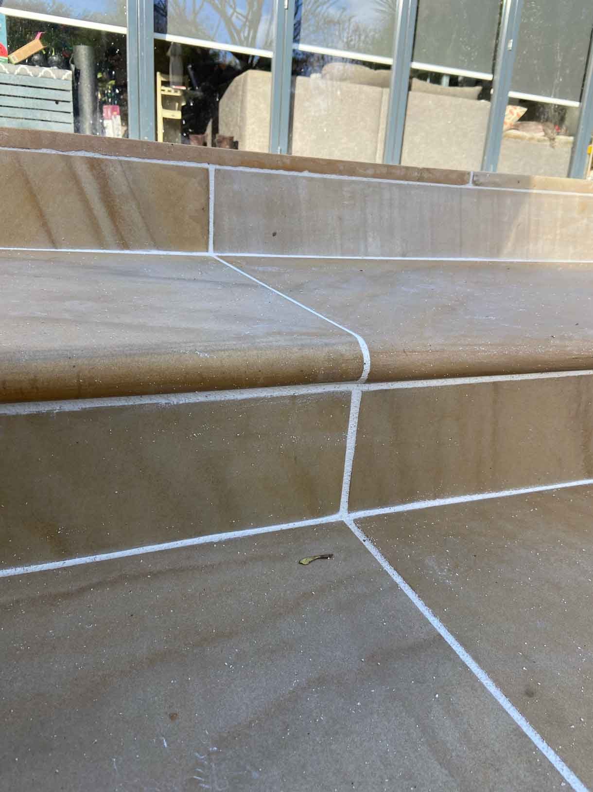 A new sandstone patio to complement the new house extension with steps on to the new lawn.