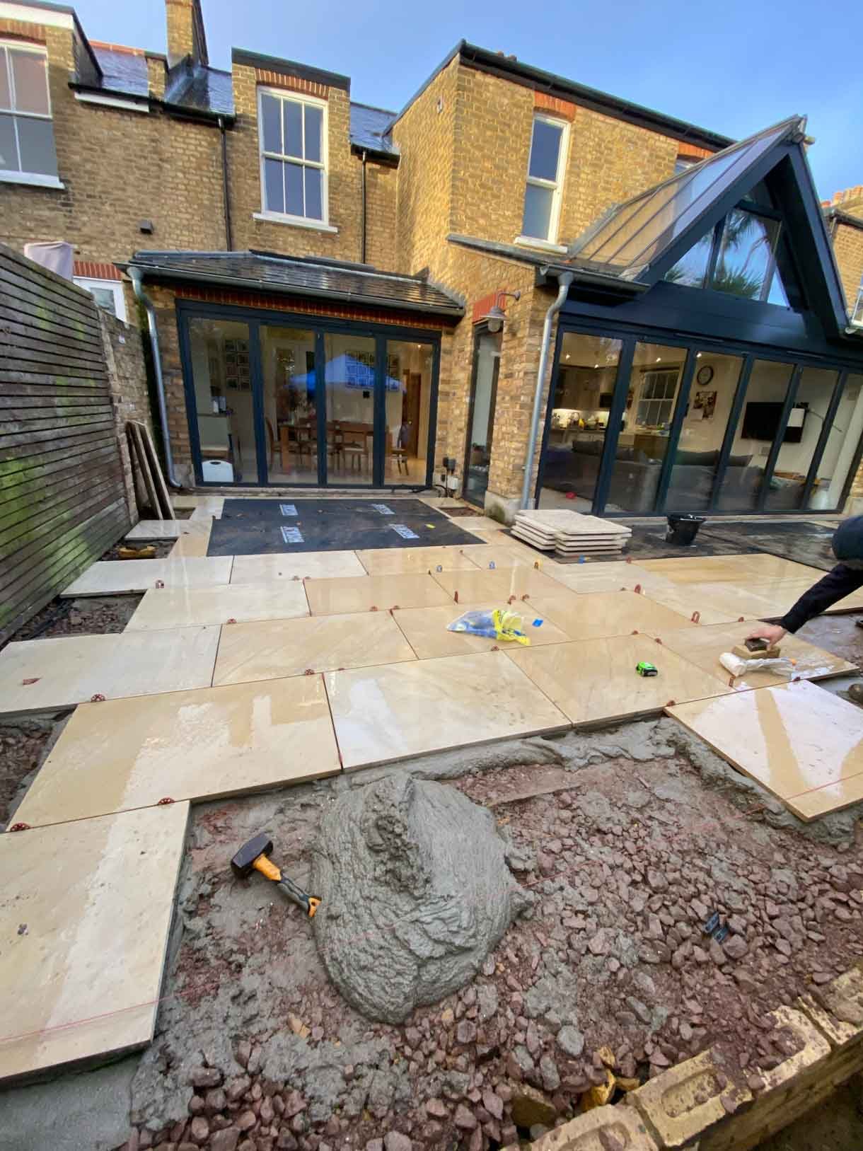 A new sandstone patio to complement the new house extension with steps on to the new lawn.