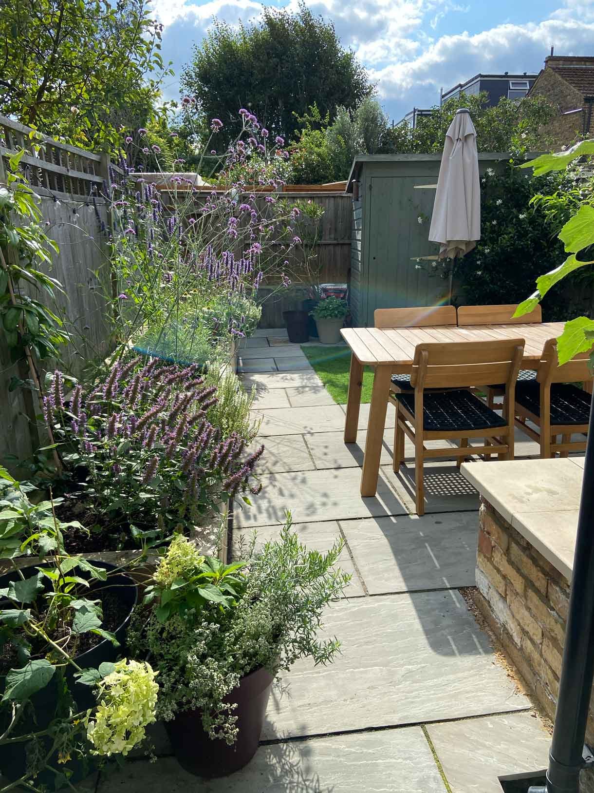 A small garden in Twickenham which we designed and built using sandstone for the patio and softwood sleepers for raised beds.