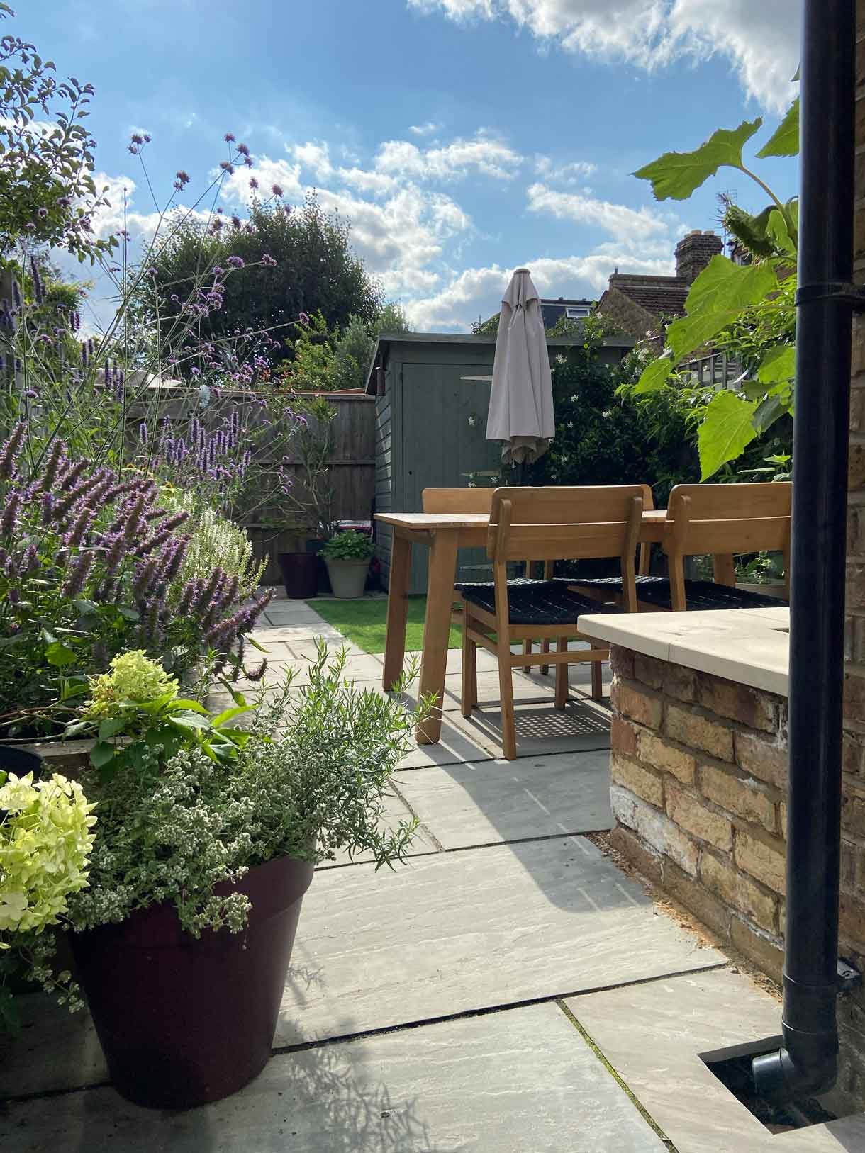 A small garden in Twickenham which we designed and built using sandstone for the patio and softwood sleepers for raised beds.