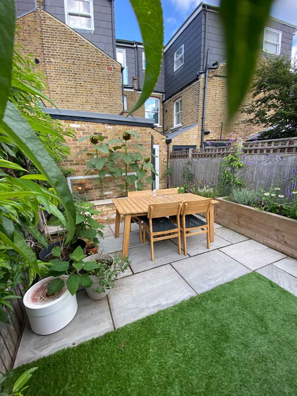 A small garden in Twickenham which we designed and built using sandstone for the patio and softwood sleepers for raised beds.