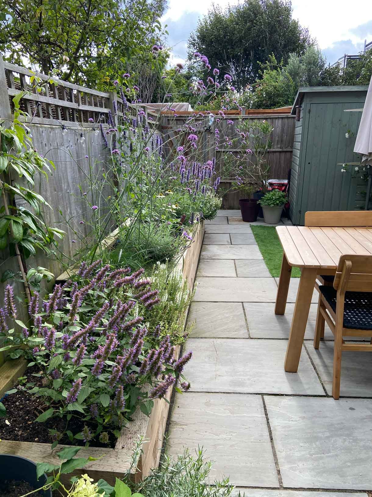 A small garden in Twickenham which we designed and built using sandstone for the patio and softwood sleepers for raised beds.