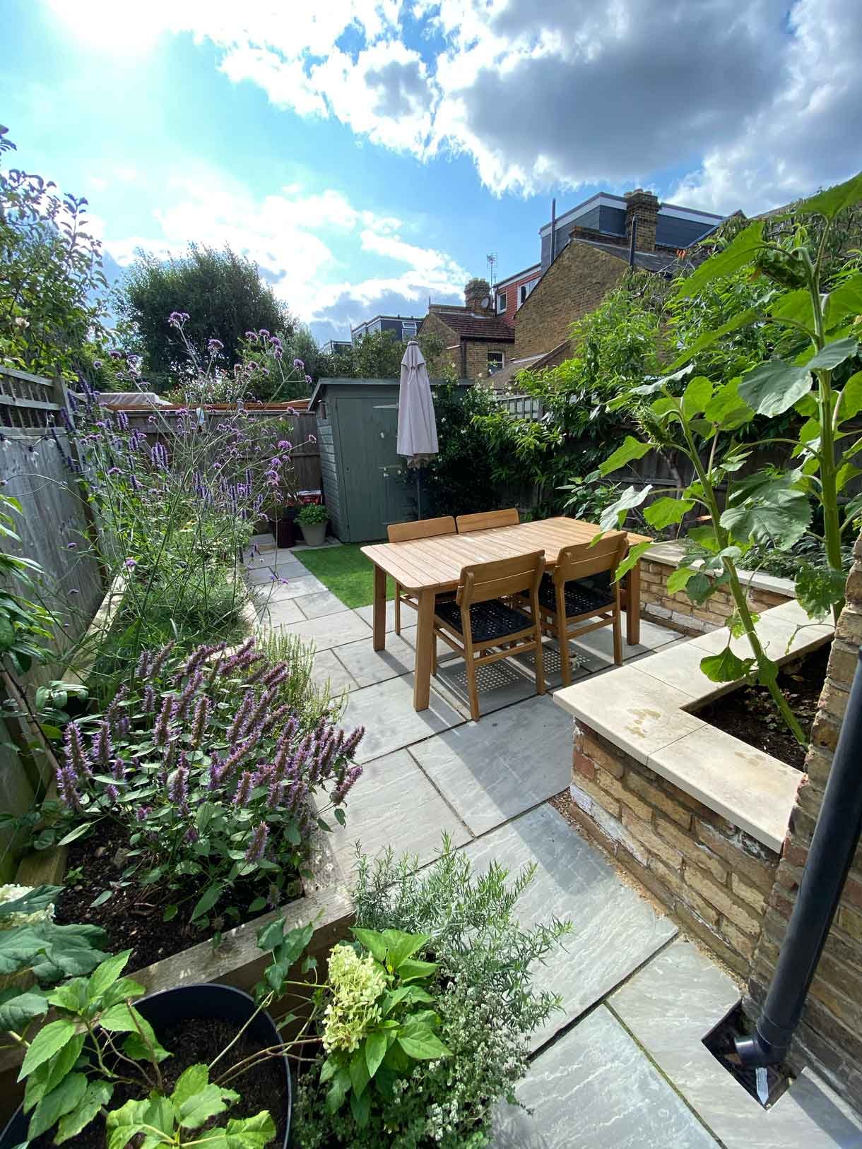 A small garden in Twickenham which we designed and built using sandstone for the patio and softwood sleepers for raised beds.