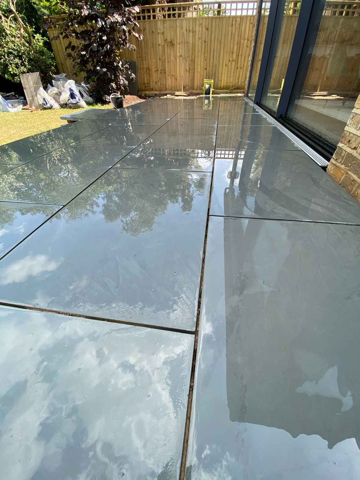 A raised grey slate patio in Teddington, with white rendered planters.