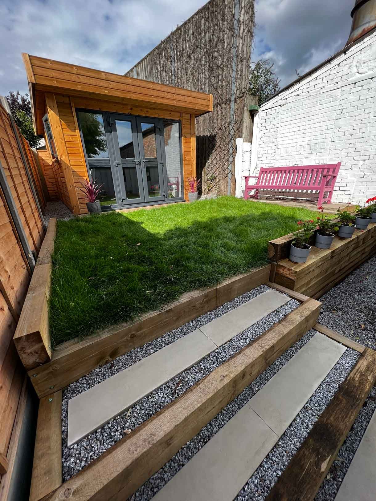 A long garden with stepping stones and lighting which leads to the new garden room at the bottom of the garden.