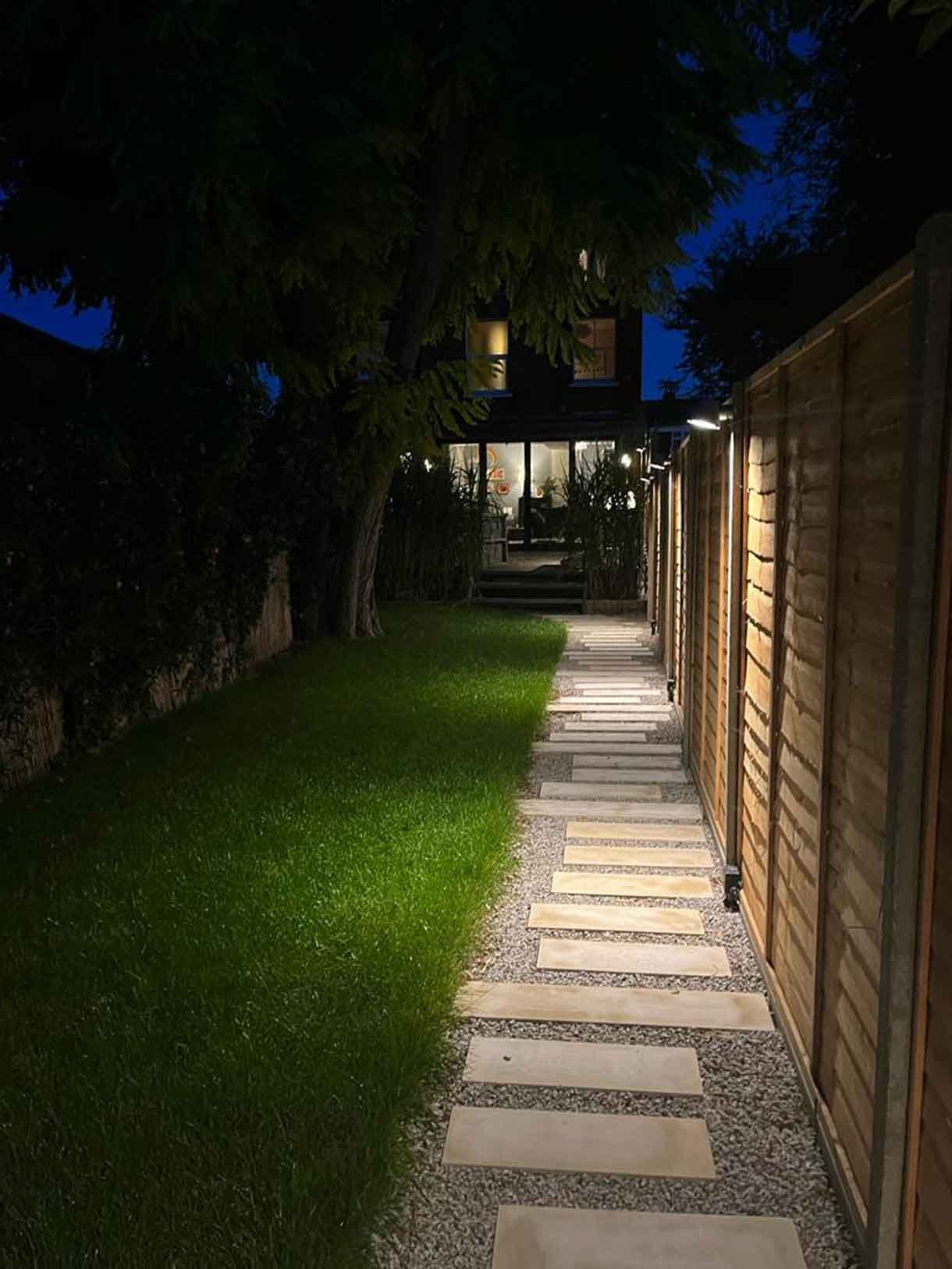 A long garden with stepping stones and lighting which leads to the new garden room at the bottom of the garden.