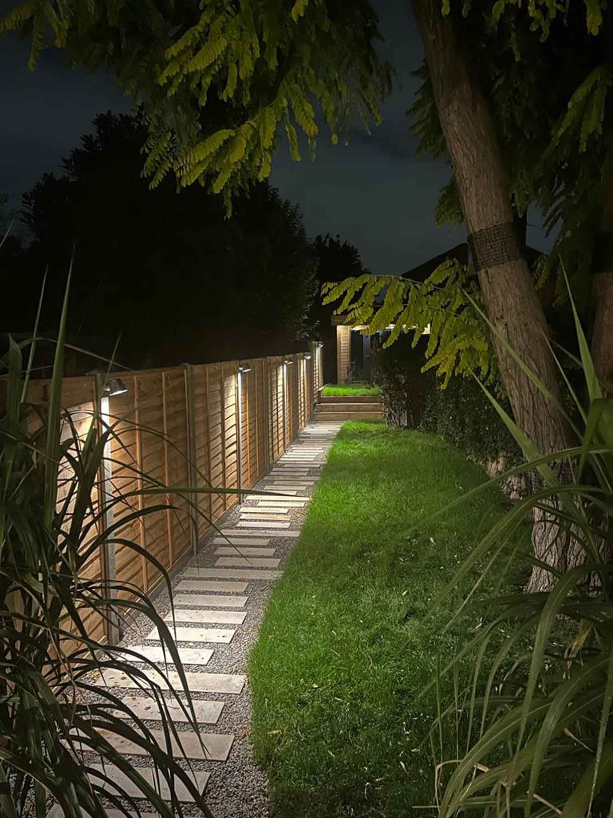 A long garden with stepping stones and lighting which leads to the new garden room at the bottom of the garden.