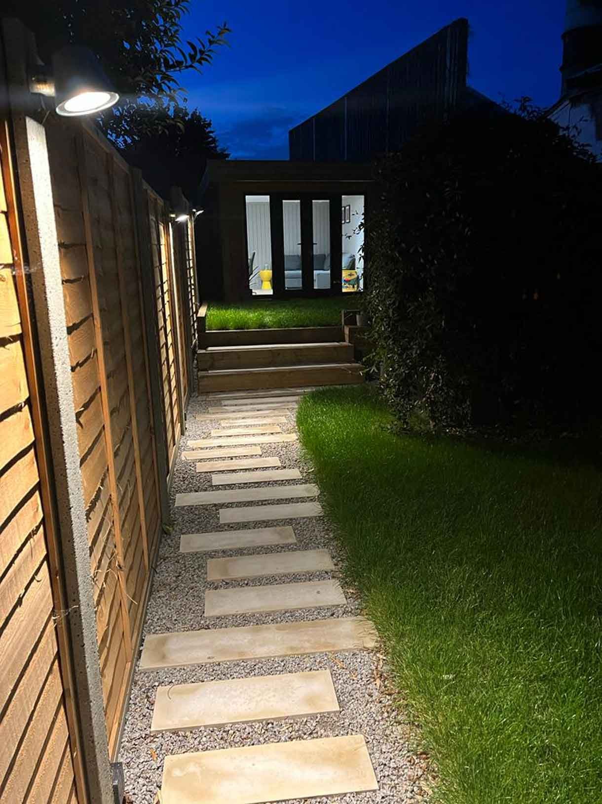 A long garden with stepping stones and lighting which leads to the new garden room at the bottom of the garden.