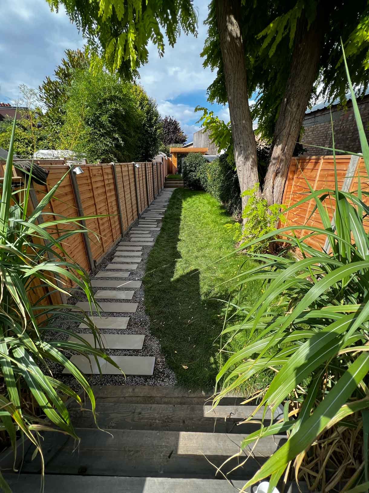 A long garden with stepping stones and lighting which leads to the new garden room at the bottom of the garden.