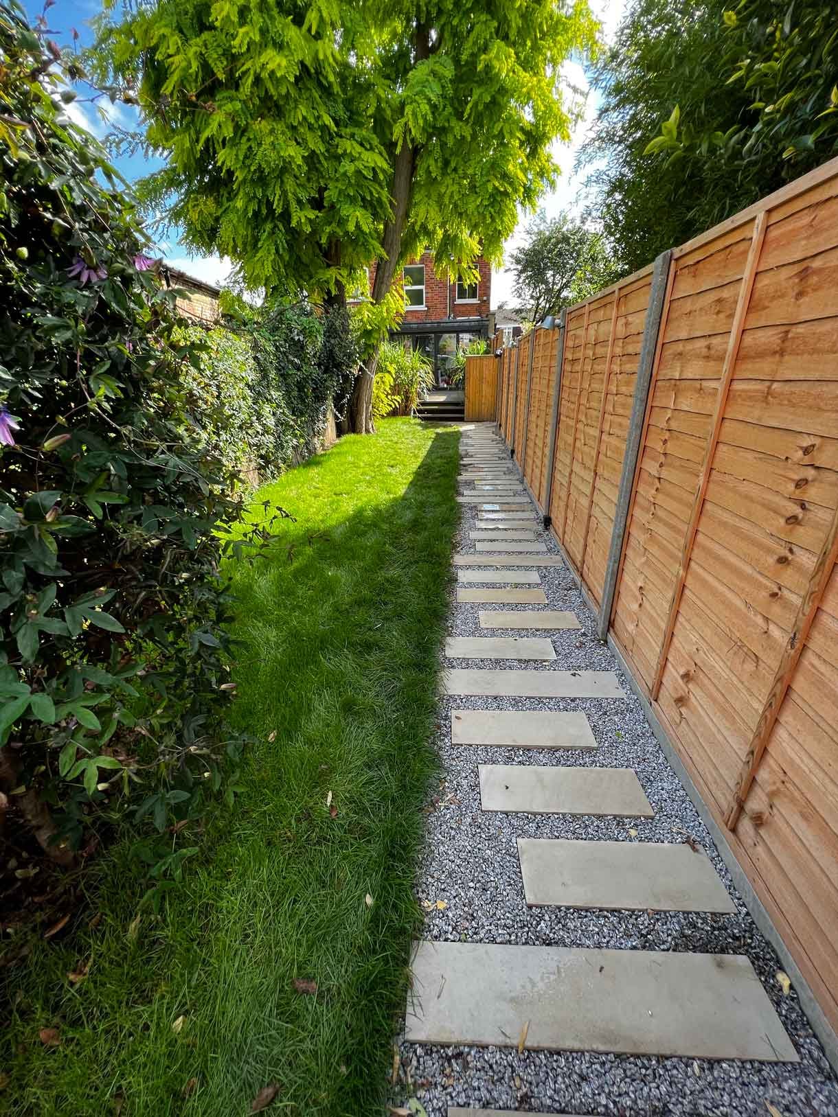 A long garden with stepping stones and lighting which leads to the new garden room at the bottom of the garden.