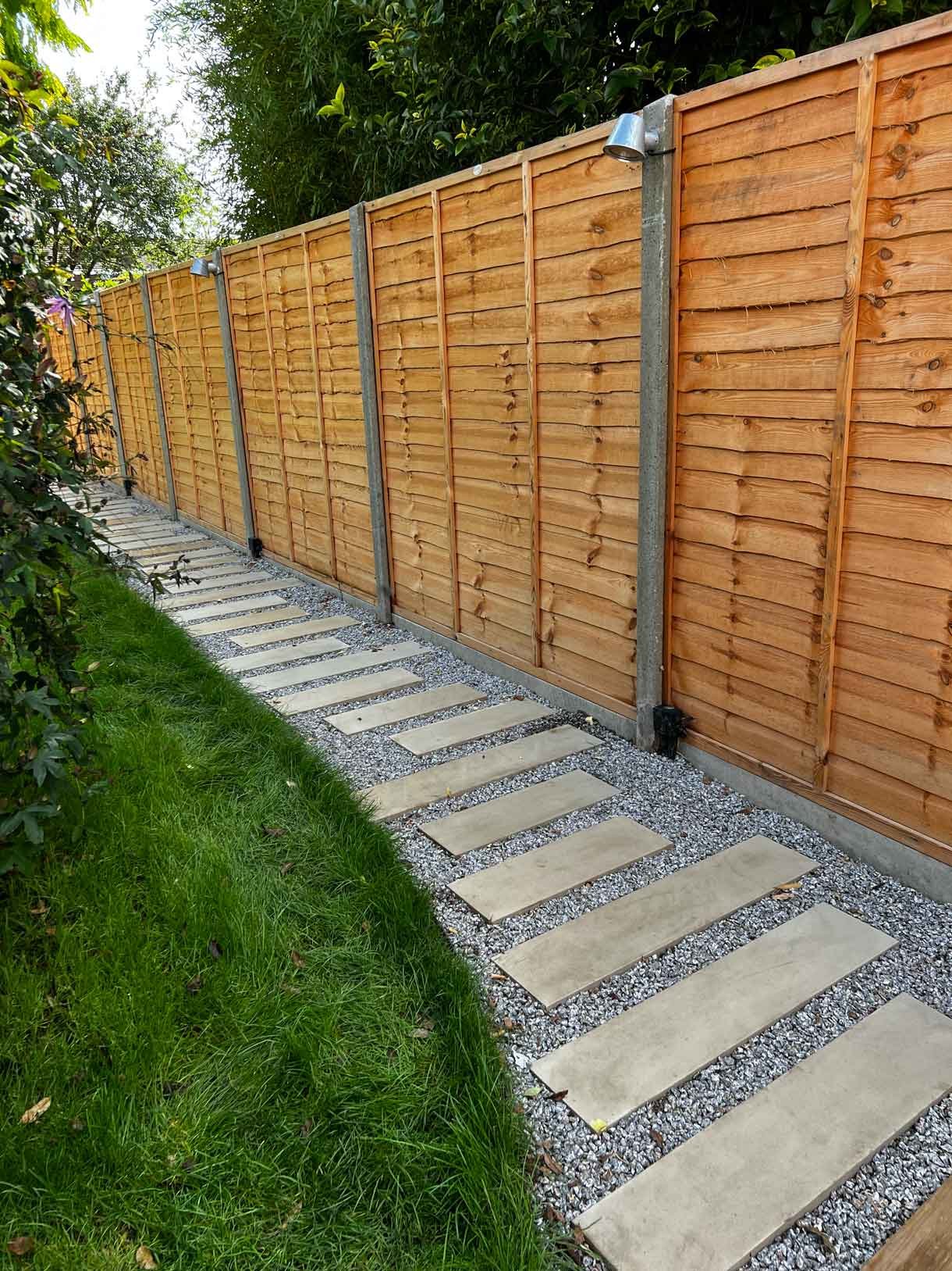 A long garden with stepping stones and lighting which leads to the new garden room at the bottom of the garden.