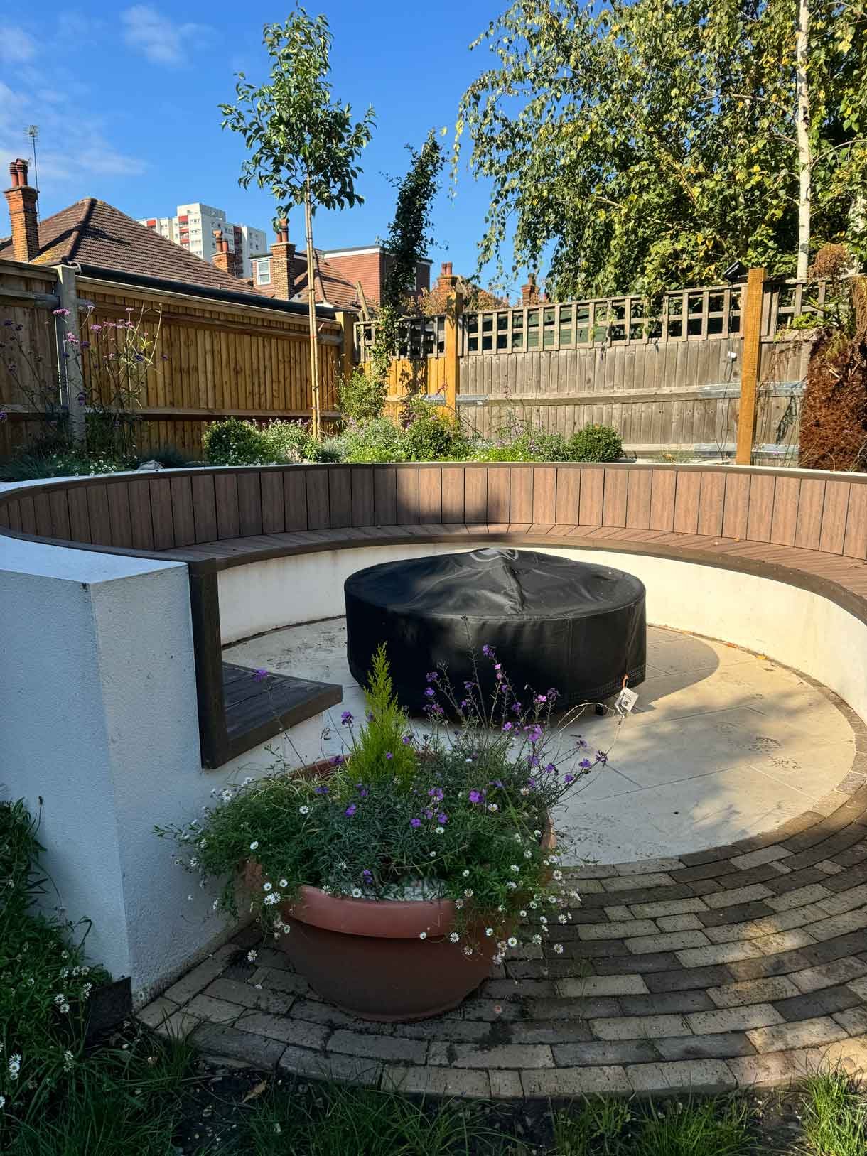 A rendered circular seating area also made from composite with a fire pit in the middle.