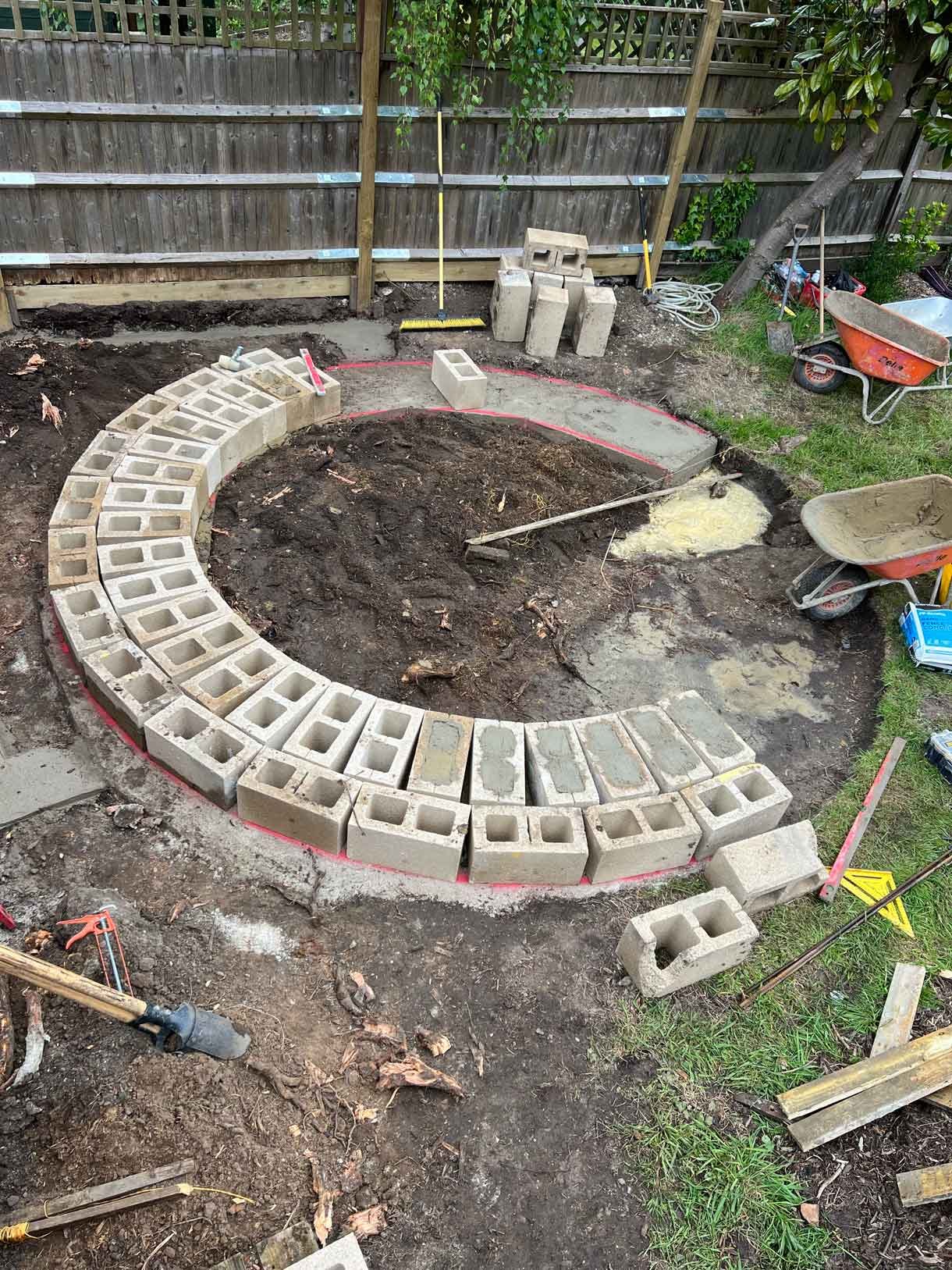 A rendered circular seating area also made from composite with a fire pit in the middle.
