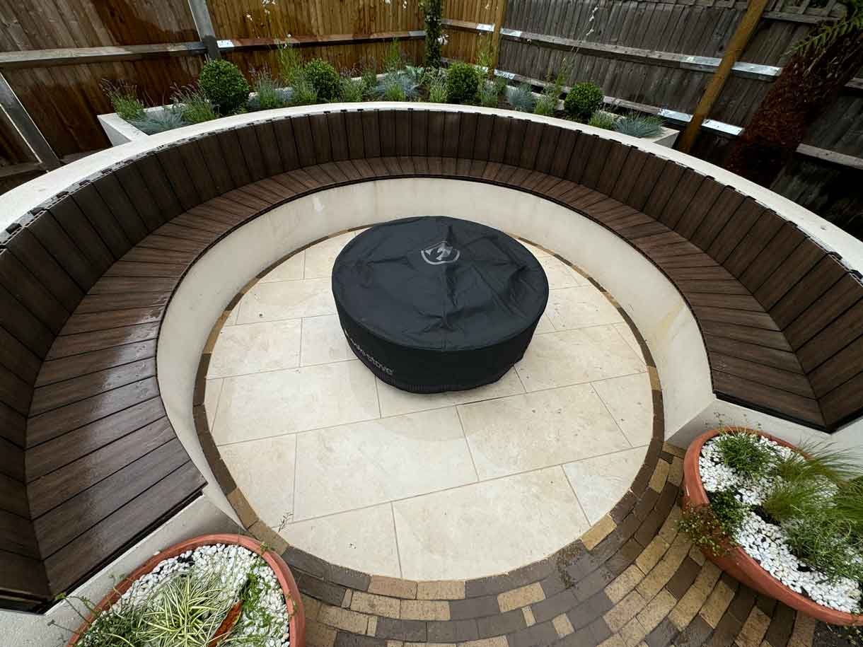 A rendered circular seating area also made from composite with a fire pit in the middle.