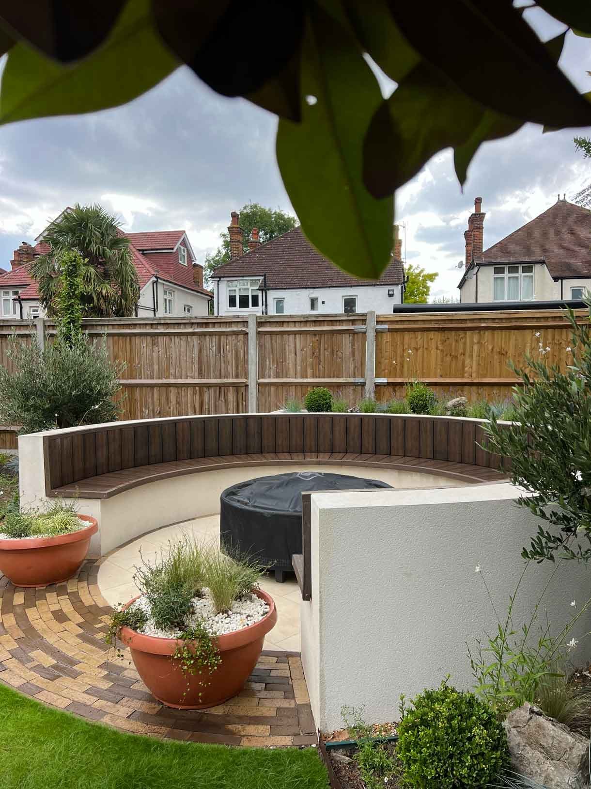 A rendered circular seating area also made from composite with a fire pit in the middle.
