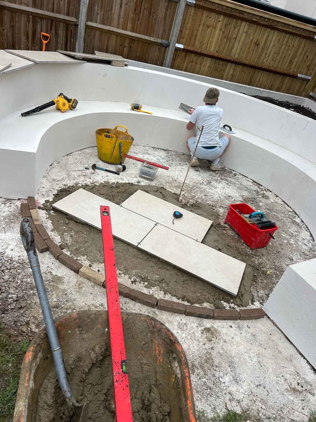 A rendered circular seating area also made from composite with a fire pit in the middle.