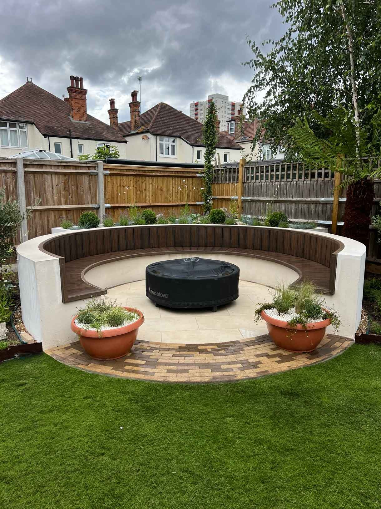A rendered circular seating area also made from composite with a fire pit in the middle.