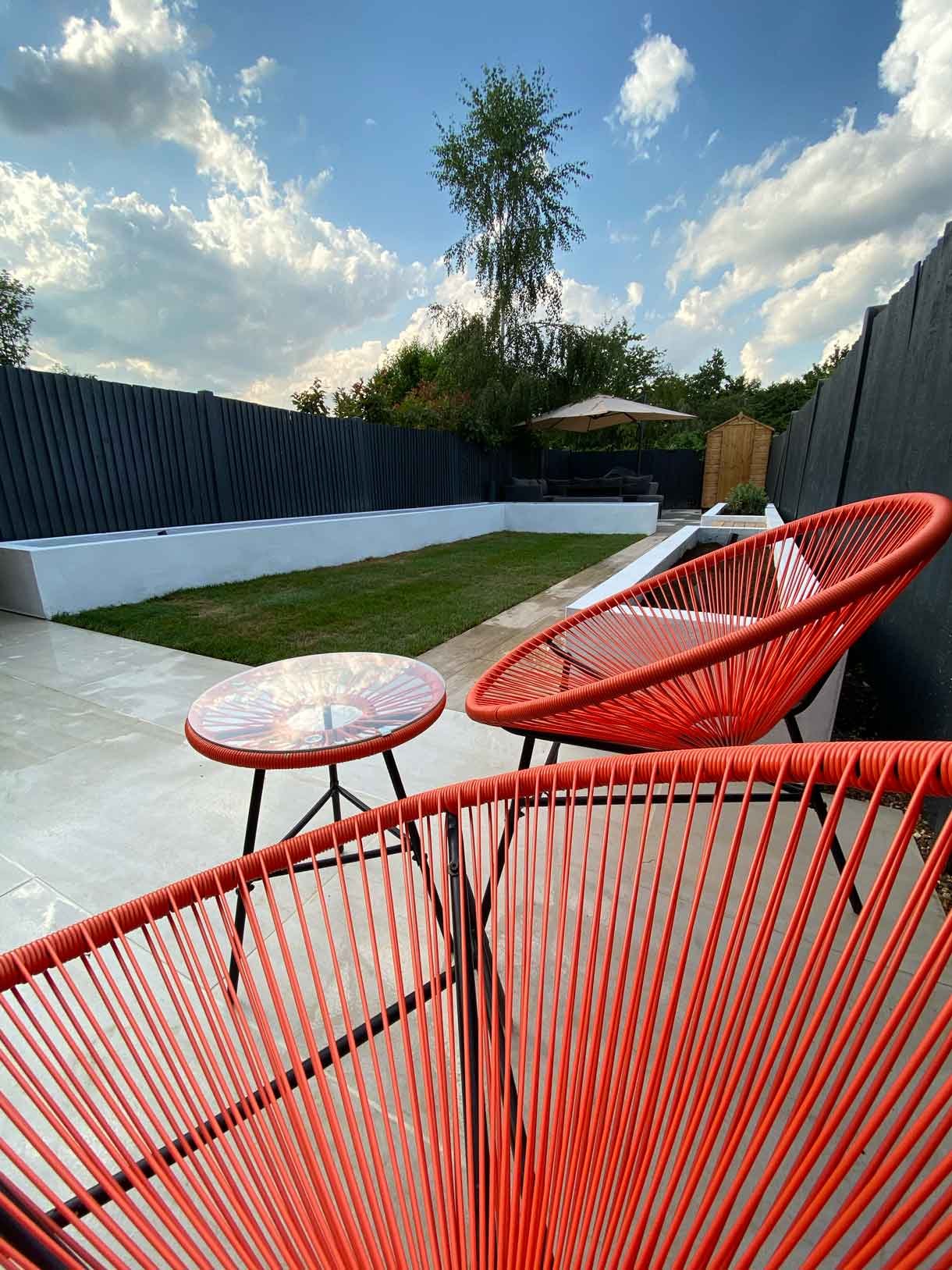 A garden redesign in Tooting, with raised planters, seating area and raised patio at the back of the garden with garden lighting throughout.