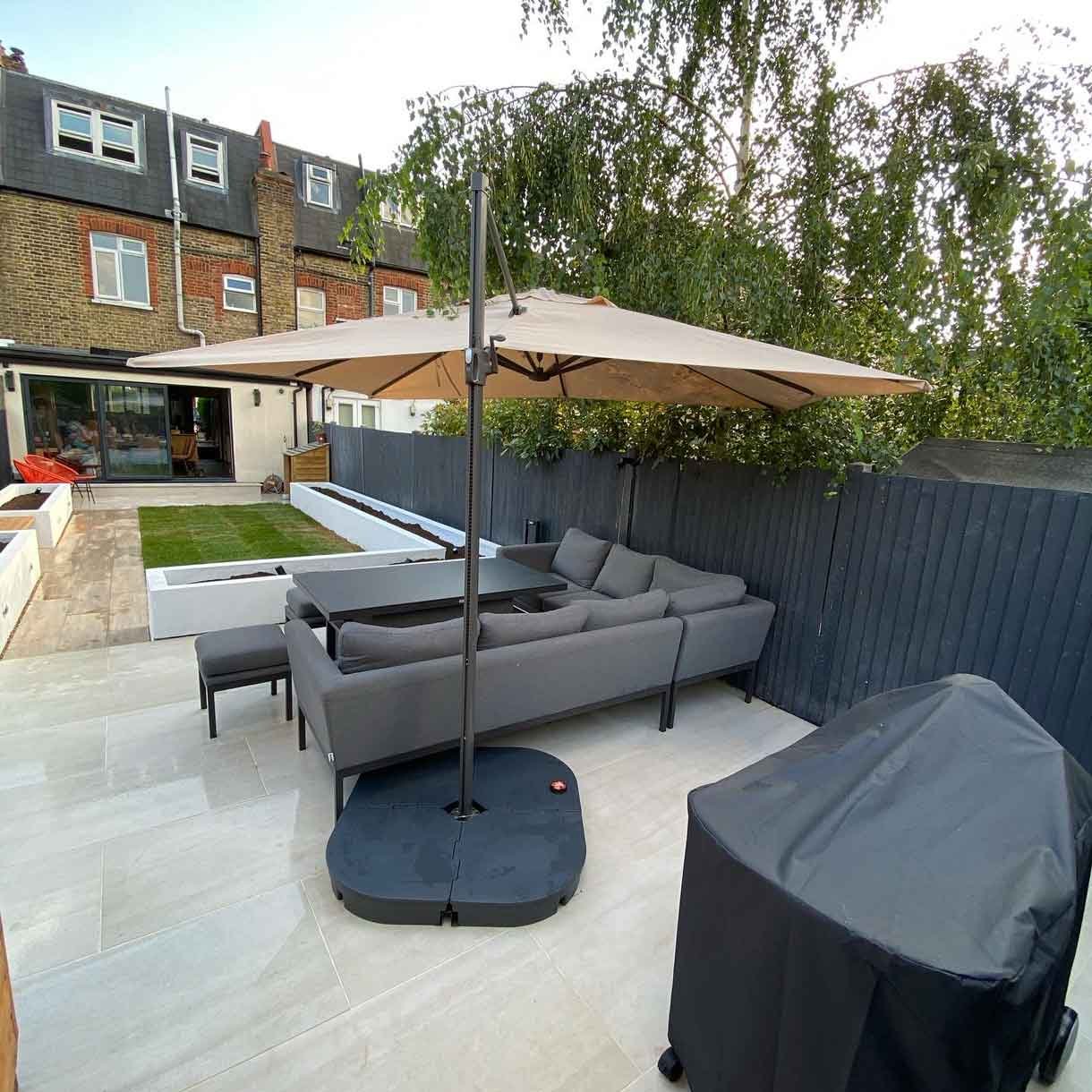 A garden redesign in Tooting, with raised planters, seating area and raised patio at the back of the garden with garden lighting throughout.